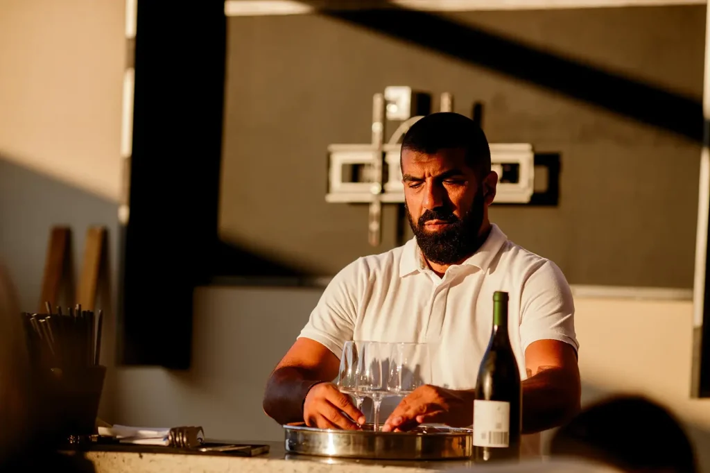 Bartender pouring local wine at the bar of Marshal Club Hotel Vis